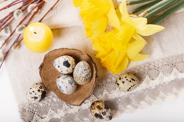 Sfondo di Pasqua con uova di Pasqua salice e fiori di primavera gialli narcisi Vista dall'alto con spazio per la copia