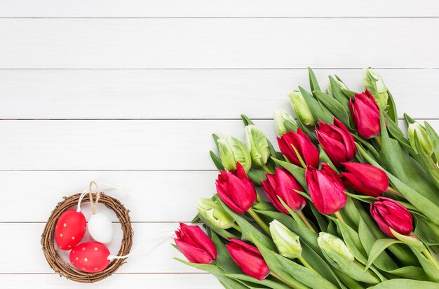 Sfondo di Pasqua. Tulipani rossi e bianchi e uova di Pasqua. Copia spazio, vista dall'alto