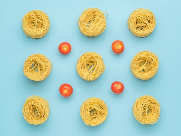 Sfondo di pasta e pomodori freschi su sfondo blu.