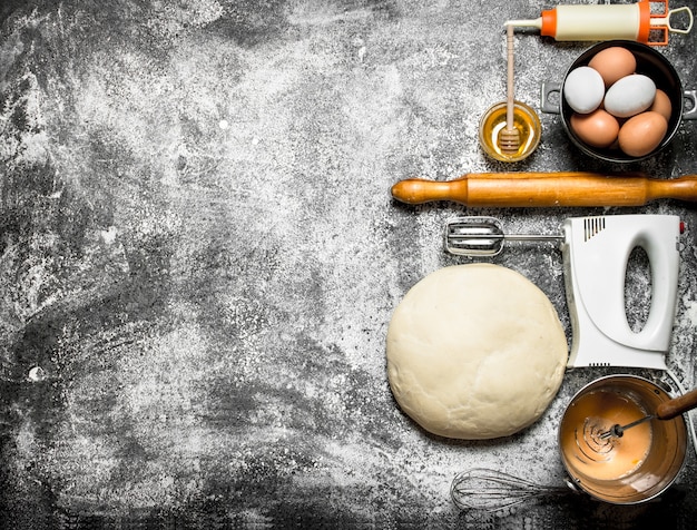 Sfondo di pasta. L'impasto con il mixer e vari ingredienti.