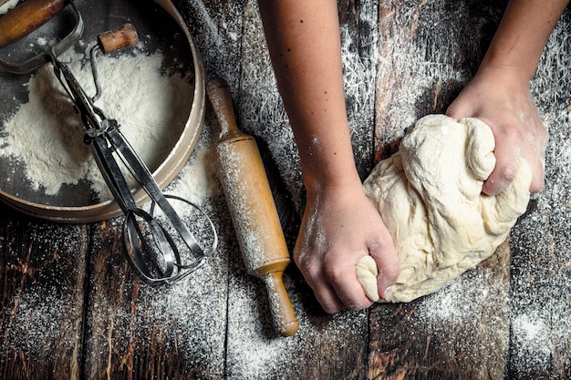 Sfondo di pasta. Preparazione dell'impasto con strumenti. Su un tavolo di legno.