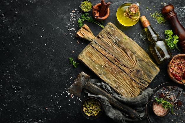 Sfondo di pietra da cucina nera con tavole da cucina e utensili da cucina. Spazio libero per il testo. Vista dall'alto.