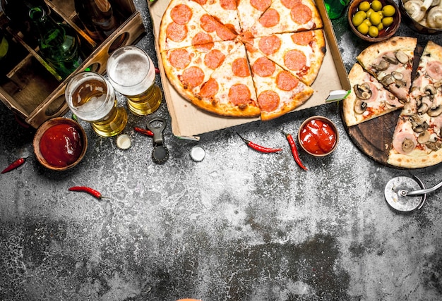 Sfondo di pizza. Peperoni con birra sul tavolo rustico.