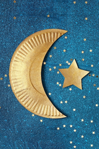 Sfondo di Ramadan Kareem con mezzaluna d'oro e stelle.