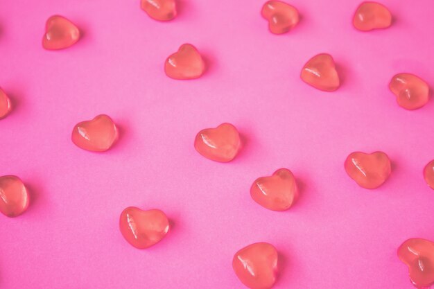 Sfondo di San Valentino con caramelle a forma di cuore sul tavolo rosa