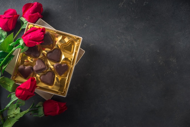 Sfondo di San Valentino con cuori di cioccolato e rose rosse