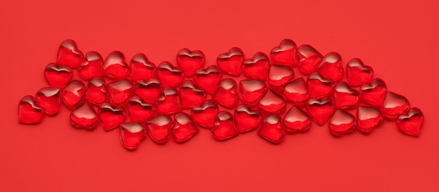 Sfondo di San Valentino con cuori rossi su sfondo rosso, vista dall'alto. Biglietto festivo del 14 febbraio, San Valentino.