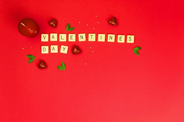 Sfondo di San Valentino su sfondo rosso, lettere e parole su cubi, decorazione e cuori rossi, copia spazio foto