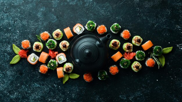 Sfondo di sushi Assortimento di sushi e tè di cibo giapponese su sfondo di pietra nera Vista dall'alto Spazio libero per il testo