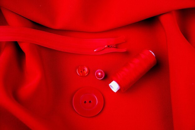 Sfondo di tessuto rosso fili bottoni cerniera La trama del tessuto