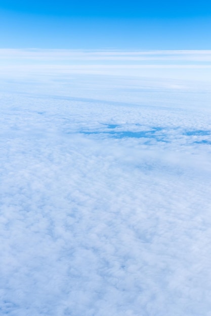 Sfondo di un cielo blu celeste con soffici nuvole dense vista dall'alto da un telaio verticale dell'aeroplano Sky Gradient