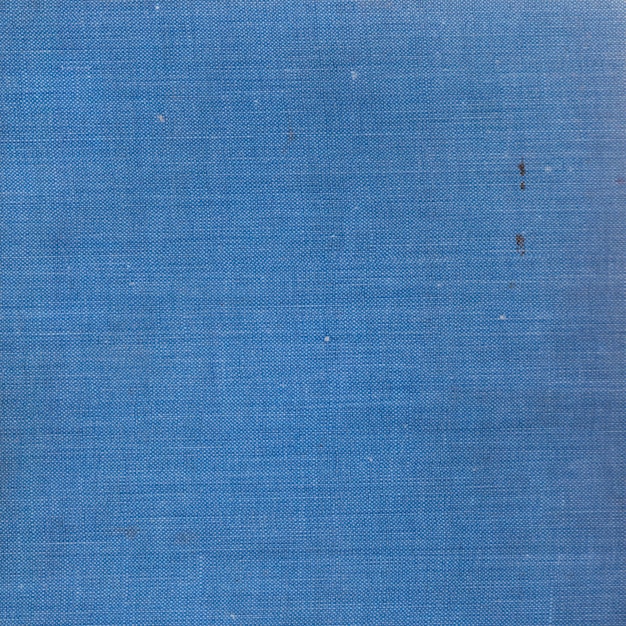 Sfondo di una vecchia trama di stoffa blu con copertina rigida