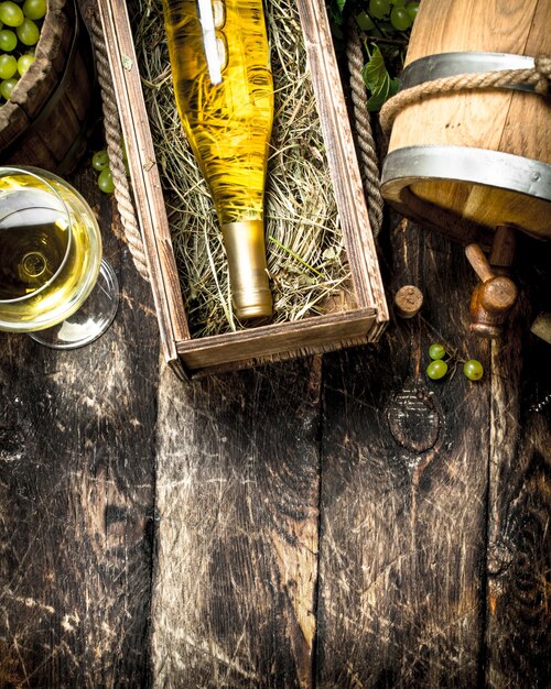 Sfondo di vino. Vino bianco con un secchio di uva verde. Su uno sfondo di legno.