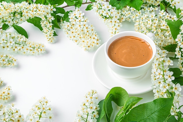 Sfondo estivo con fiori e caffè su sfondo bianco. Vista laterale, copia dello spazio.