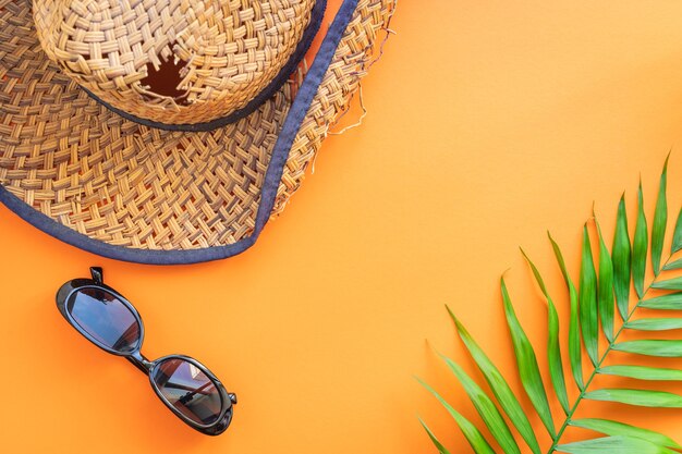 sfondo estivo con foglie, occhiali da sole e cappello di paglia