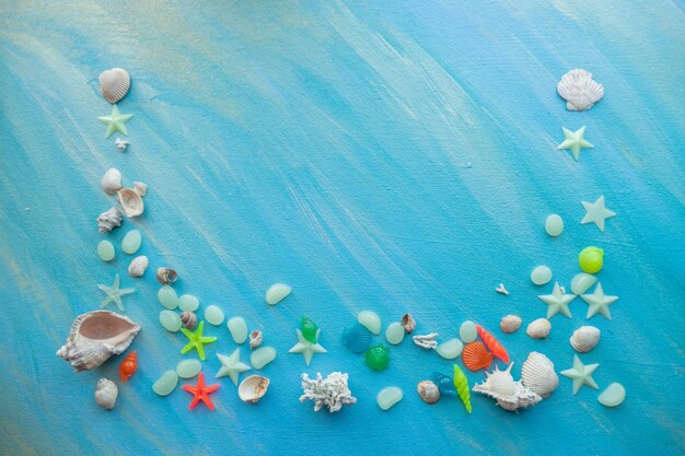 Sfondo estivo di conchiglie Molte diverse stelle marine di conchiglie su uno sfondo di tratti di vernice turchese Posizionare il testo con un bordo sul bordo inferiore