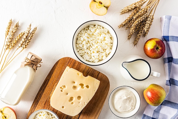 Sfondo festivo per la festa primaverile ebraica di Shavuot molti prodotti lattiero-caseari mele e spighe di pane vista dall'alto piatto