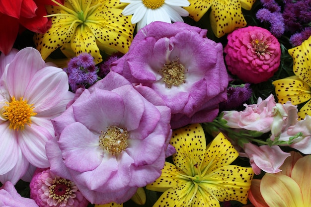 Sfondo floreale con gigli gialli e rose viola