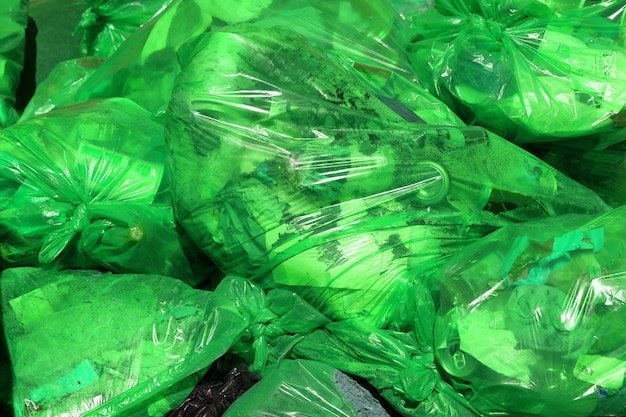 Sfondo full frame di sacchi per la spazzatura in plastica verde con rifiuti domestici generici