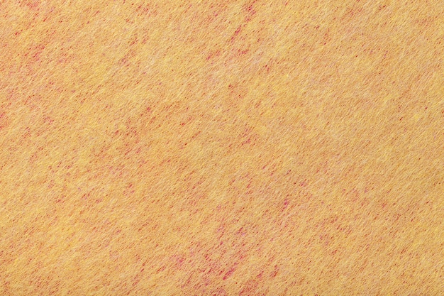 Sfondo giallo chiaro e rosso di tessuto feltro. Trama di tessuto di lana