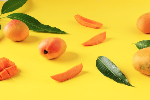 Sfondo giallo Concetto di mango maturo con foglia di mango fresco. Varian Mango Taglia e Servi con Mangga Gedong Gincu da West Java, Indonesia