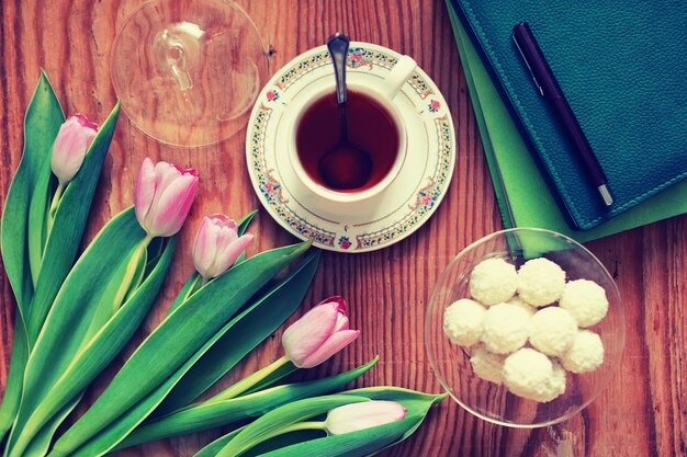 Sfondo in legno con tulipano e tè