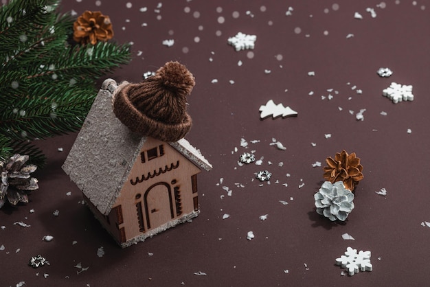 Sfondo invernale accogliente Figura di casa in legno con decorazione tradizionale di Natale Proprietà di Capodanno luce dura ombra scura sfondo marrone scuro spazio di copia