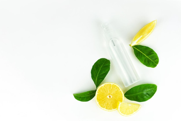 Sfondo minimalista creativo per la cura della pelle estiva con fette di frutta fresca di limone e cosmetici rinfrescanti spray per nebulizzazione in bottiglia. Copia spazio.