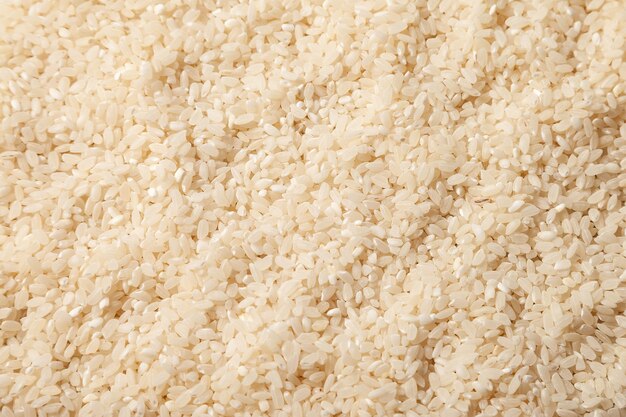Sfondo mucchio mucchio di riso da vicino. Semole di riso alimentare foto macro. Semole di riso del grano del fondo di struttura. Immagine prodotto alimentare per la cottura del porridge. Copia spazio