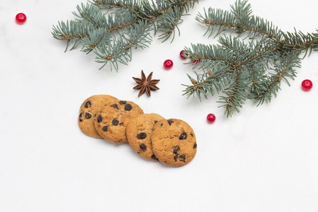 Sfondo natalizio con biscotti, rami di abete, mirtilli, fiocchi di neve, anice stellato.