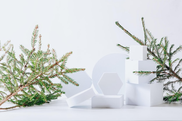 Sfondo natalizio scandinavo ecologico minimalista in colori bianchi Rami di abete e podio vuoto bianco