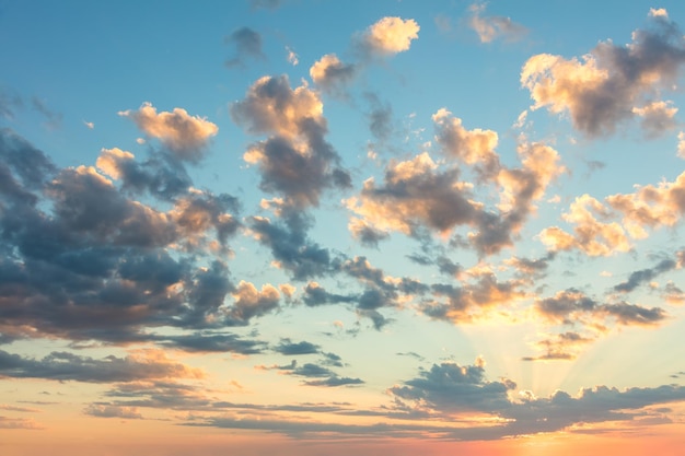 Sfondo naturale del cielo all'alba con colori delicati di nuvole morbide e raggi solari di grandi dimensioni