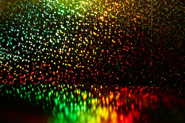 Sfondo nero astratto con scintillii brillanti rosso giallo verde shimmer Disco party sfondo luci cerchi