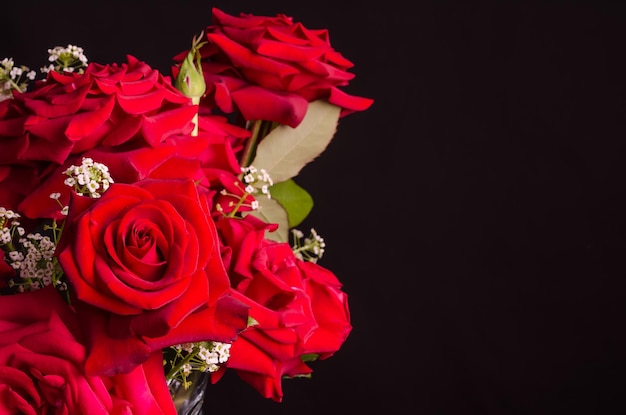 Sfondo nero con un bouquet di splendide rose rosse con spazio per la copia