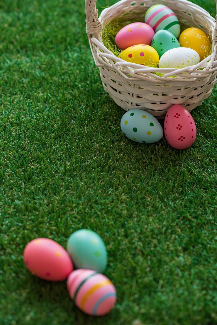 Sfondo pasquale verticale con uova di Pasqua colorate giallo rosa blu in cesto intrecciato ed erba verde Vista dall'alto con spazio per la copia Sfondo dei social media delle vacanze di Pasqua