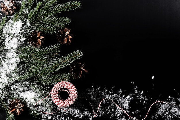 Sfondo per auguri di Natale con rami di albero, coni e neve