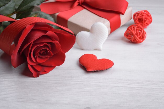 Sfondo per il giorno di San Valentino biglietto di auguri concetto di giorno di San Valentino nastri regalo rosso, regali, cuori su un fondo di legno.