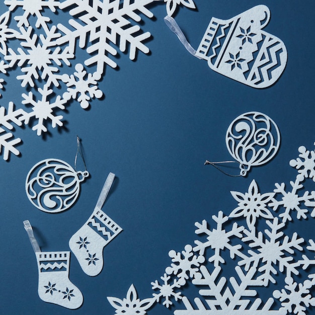 Sfondo per la cartolina di Natale con fiocchi di neve e decorazioni su sfondo blu