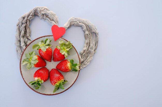 sfondo rosa. Fragole fresche in scatole regalo rosse si chiudono. Amore. San Valentino. Creativo