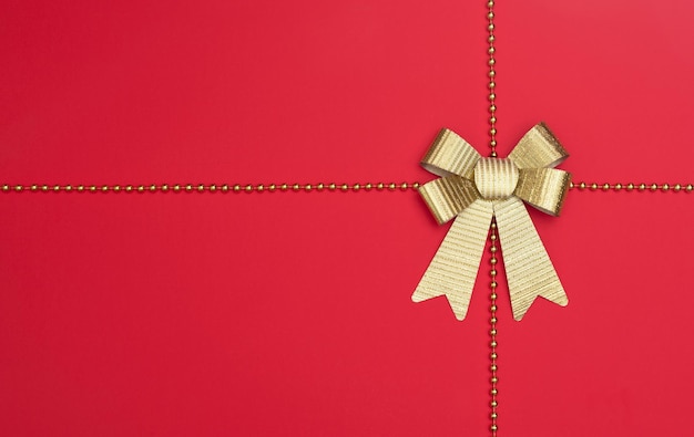 Sfondo rosso natalizio o invernale con decorazioni natalizie e perline dorate Modello di biglietto d'auguri Concetto di vacanza di Capodanno Stile piatto con spazio per la copia