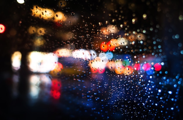 Sfondo sfocato della strada di New York City con gocce d'acqua e luci al neon quando piove la sera