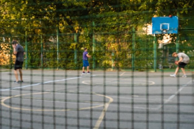 Sfondo sfocato di campo sportivo e persone che giocano a basket