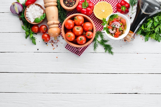 Sfondo vegetale Pomodori freschi paprika cipolle e prezzemolo sul tavolo Vista dall'alto su sfondo bianco in legno Spazio libero per il testo