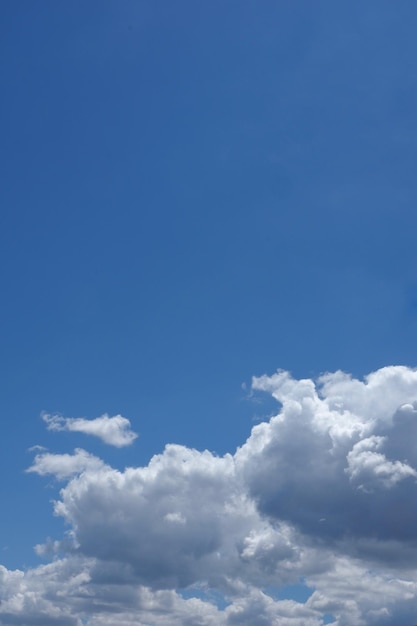 Sfondo verticale del cielo blu con nuvole Stratocumulus e raggi di sole