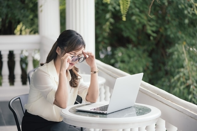 Sforzo indipendente di sensibilità della donna di affari dei giovani asiatici che lavora affare online con il computer portatile.