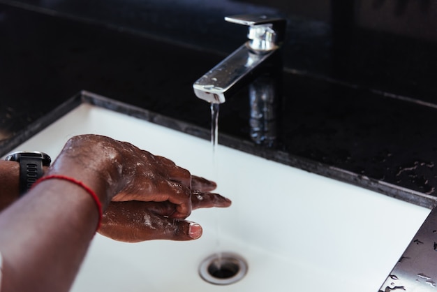 Sfregamento delle mani con acqua e sapone nei lavandini