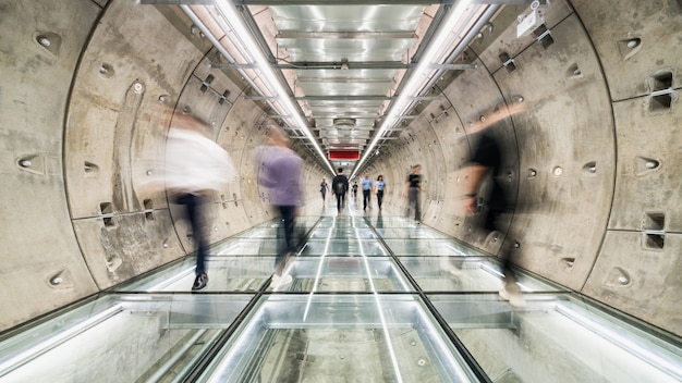 Sfuocatura di movimento della gente asiatica che cammina nel passaggio pedonale del tunnel della metropolitana