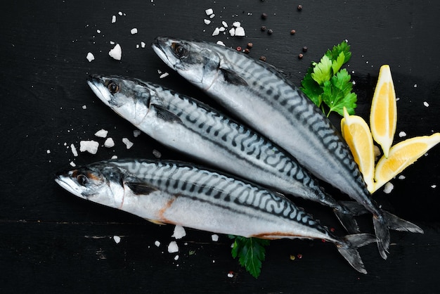 Sgombro crudo di pesce su fondo di legno nero Vista dall'alto Spazio libero per la copia