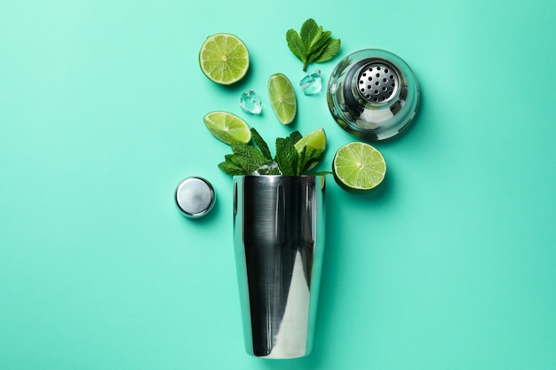 Shaker e ingredienti per il mojito su sfondo di menta