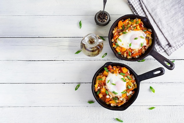 Shakshouka in padella Uova fritte con verdure pomodoro pepe zucca e cipolla Vista dall'alto